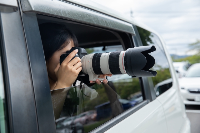 車から写真を撮る女性