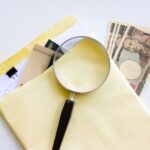 書類と虫眼鏡とお金