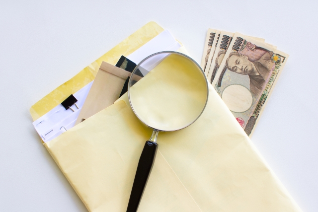 書類と虫眼鏡とお金